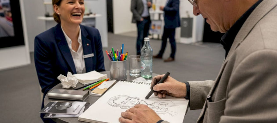 Ein Aussteller fertigt auf der Messe Karikaturen für die Besucher an.