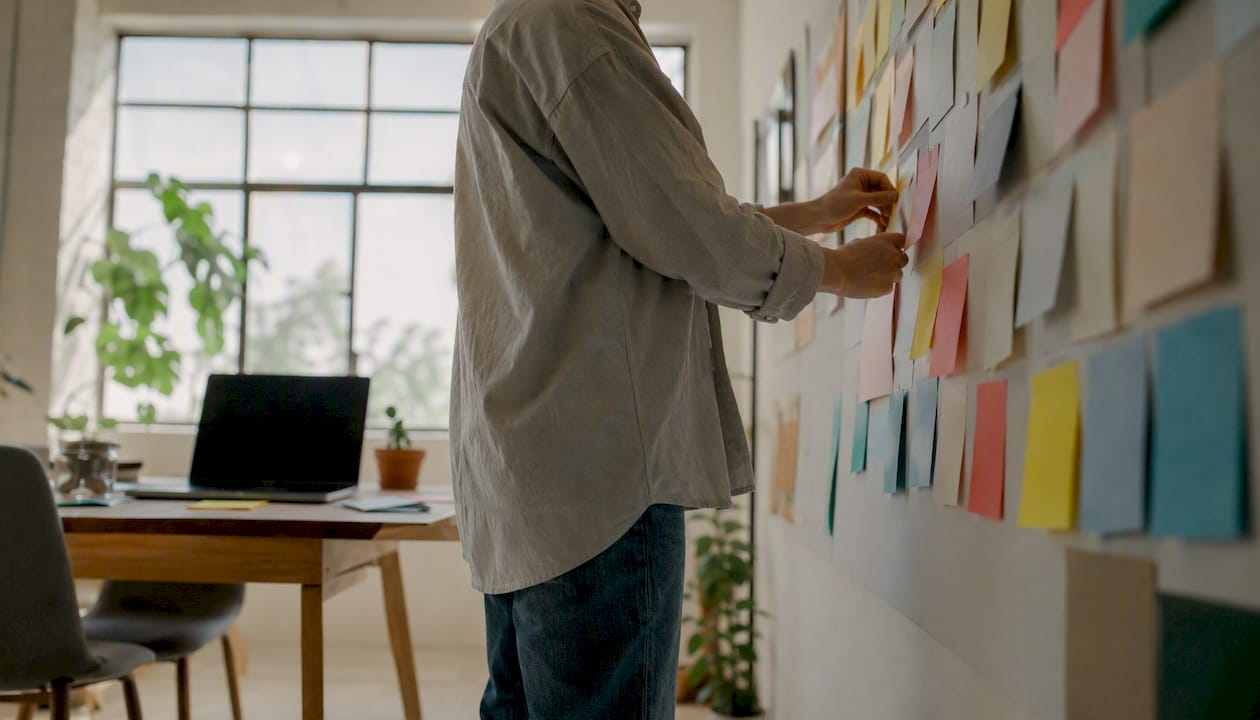 Eine Person ordnet Kundenrückmeldungen auf einem Whiteboard.