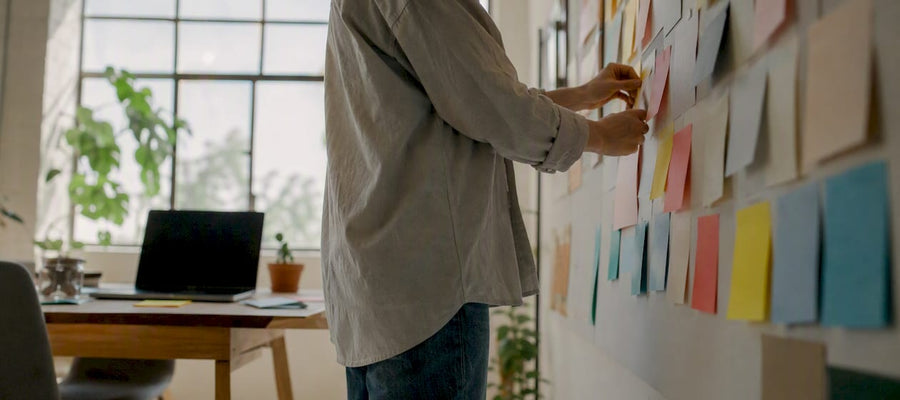 Eine Person ordnet Kundenrückmeldungen auf einem Whiteboard.